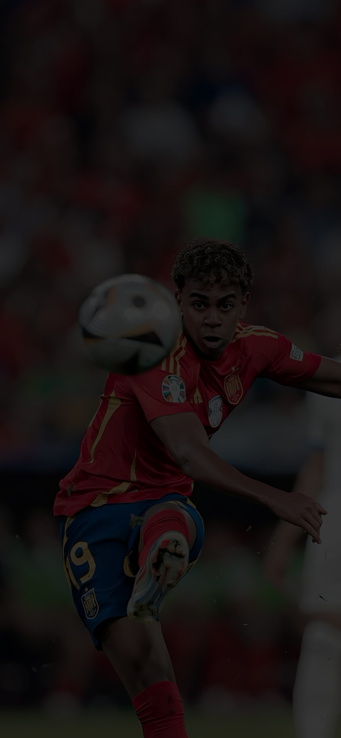 Lamine Yamal kicks the soccer ball during a match. He wears the Spanish national team jersey, and the motion blur suggests action and intensity