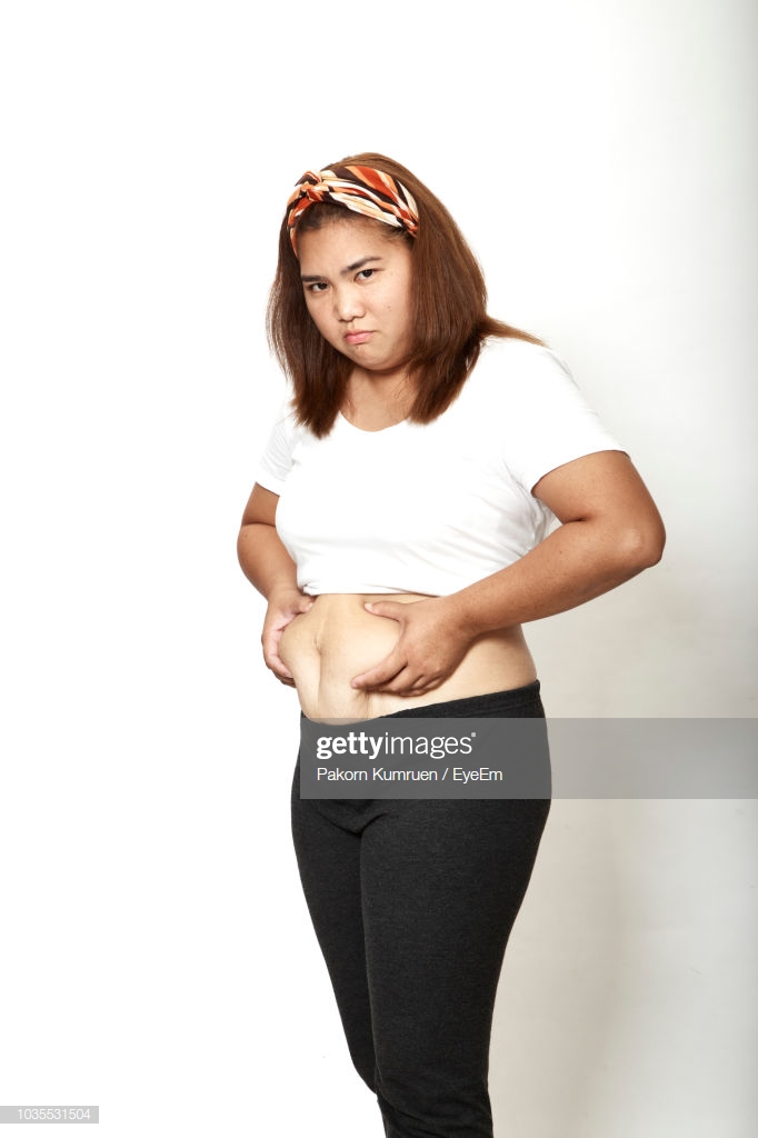 Overweight Woman Standing Against White Background Stock Photo