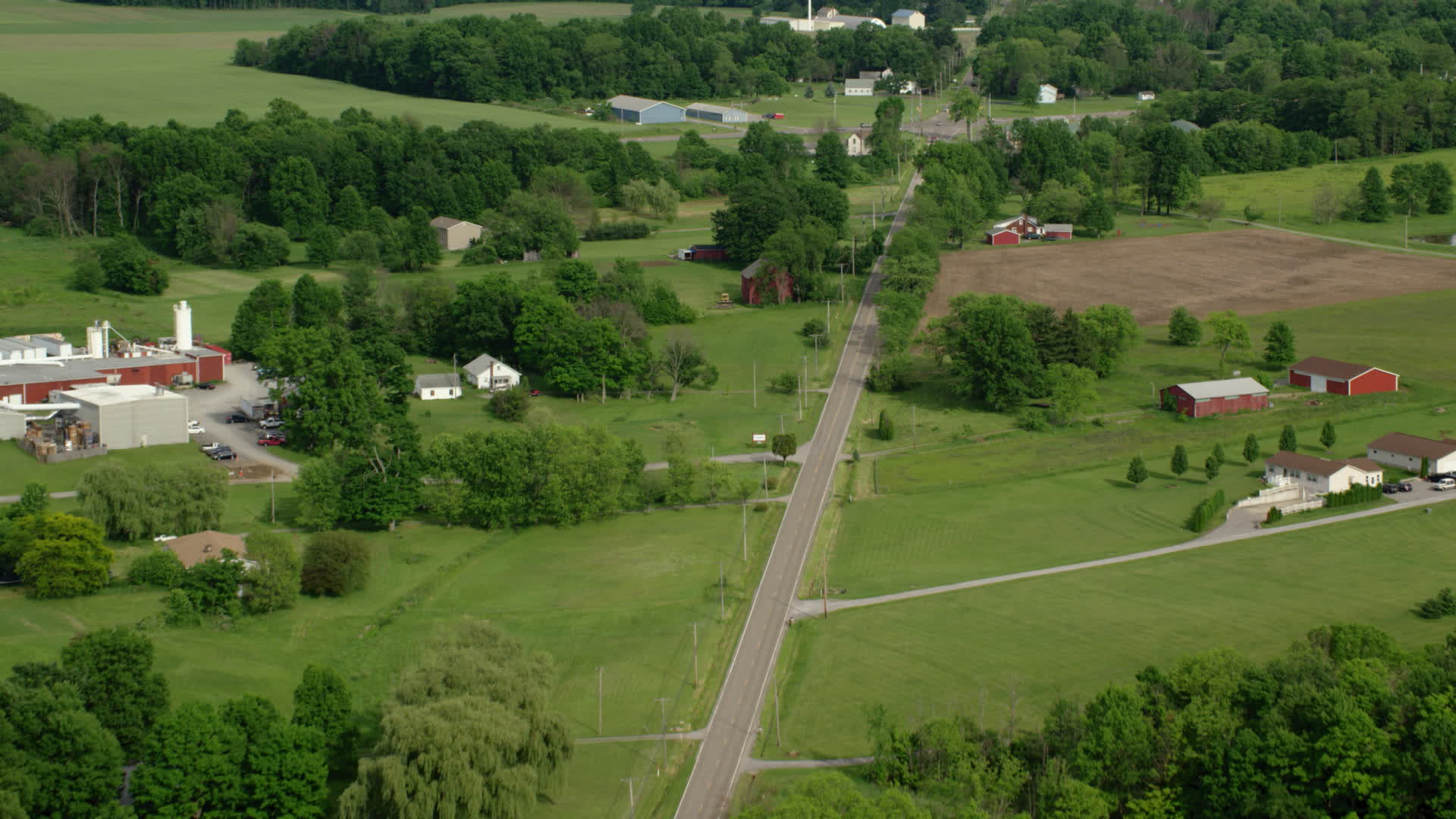 5k Stock Footage Aerial Video Following A Country Road Past Barns