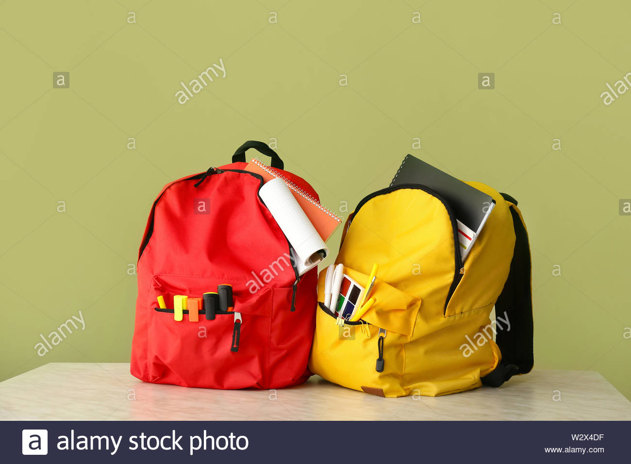 School Backpacks On Table Against Color Background Stock Photo