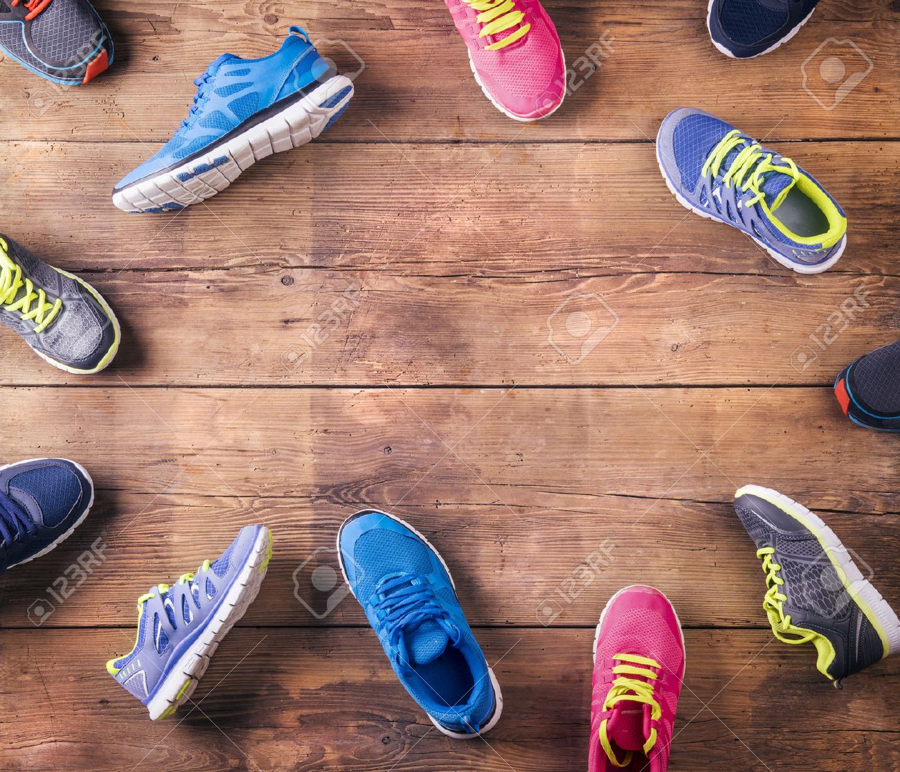 Various Running Shoes Laid On A Wooden Floor Background Stock