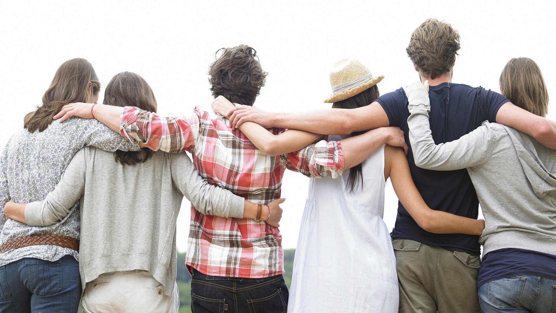 A group of friends standing together with their arms around each other, symbolizing friendship and unity