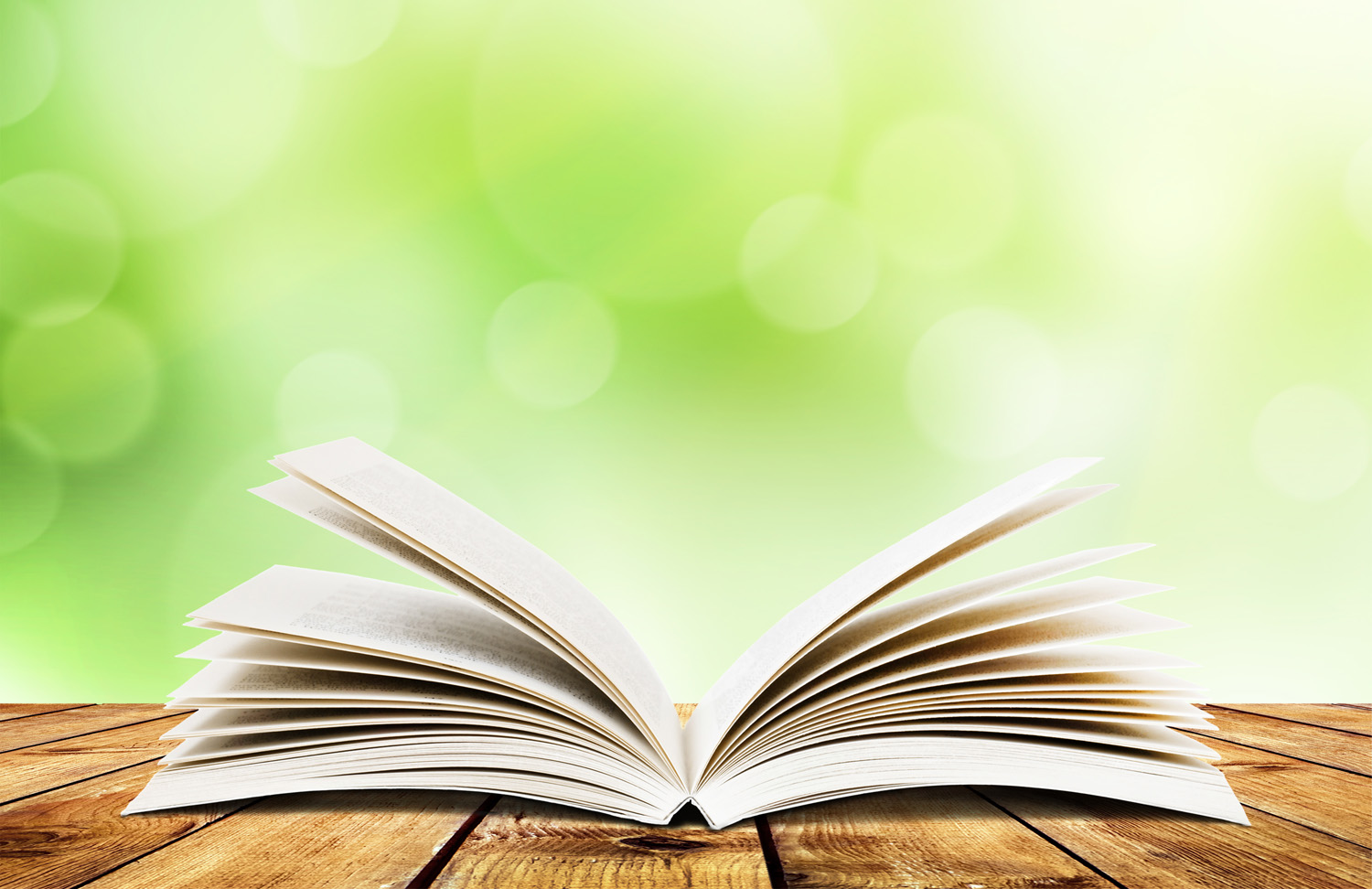 Open Book On A Table With Blurred Leafy Background