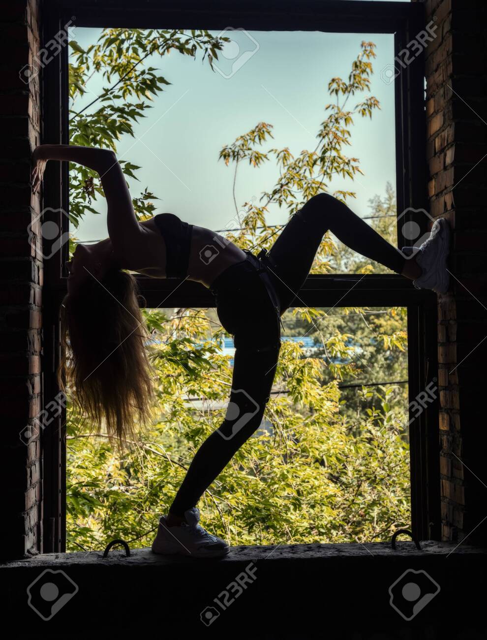 Silhouette Of Slender Girl On The Background A Large Window