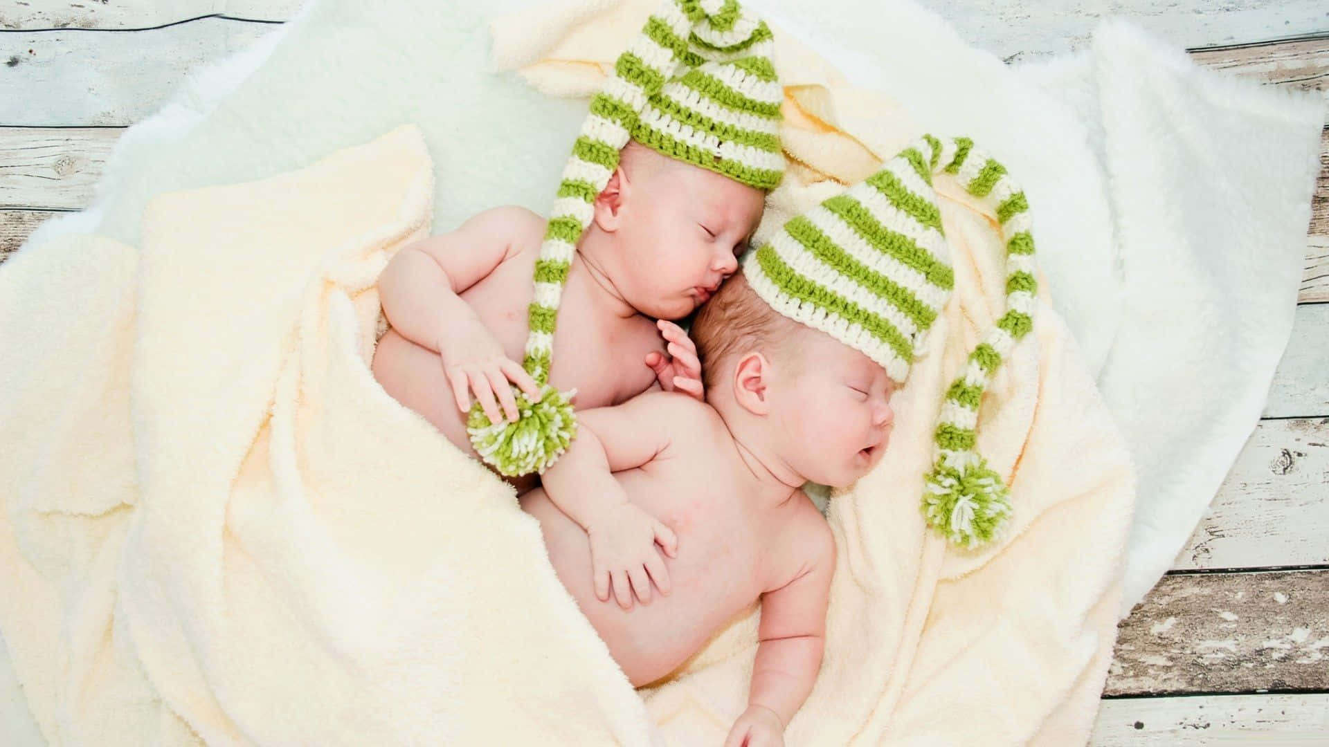 Adorable Twin Babies Smiling And Laughing Together Wallpaper