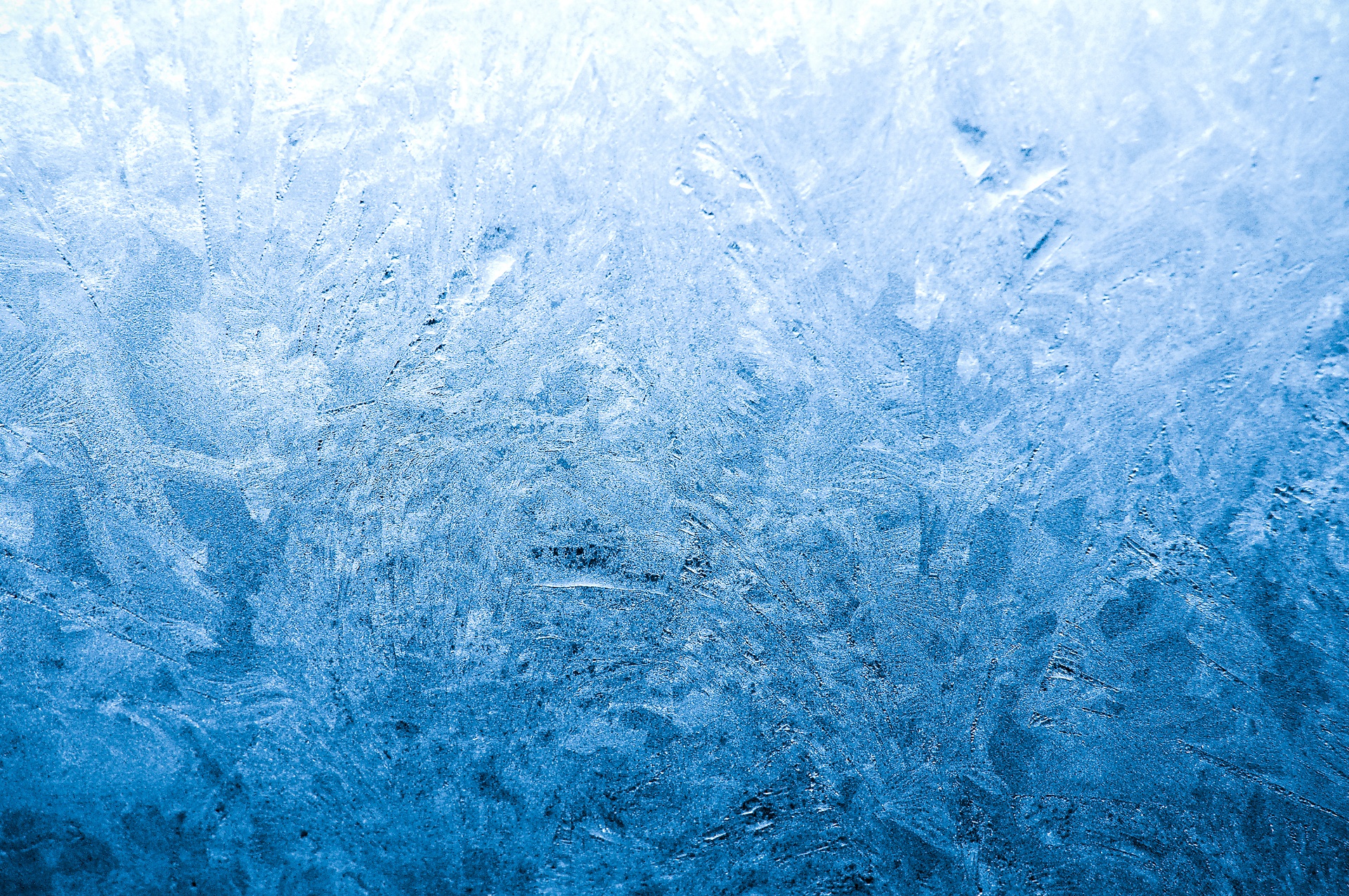 Close-up of intricate frost patterns on a window, showcasing the delicate beauty of ice crystals in winter