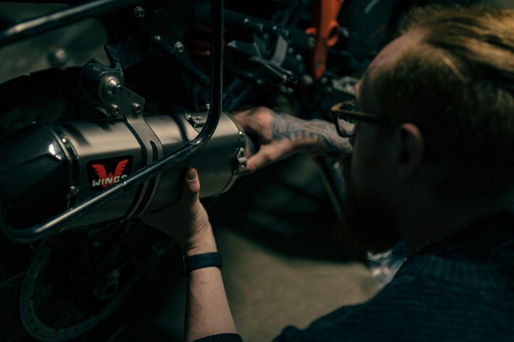 A Man Working On Motorcycle With Wrench Photo Garage