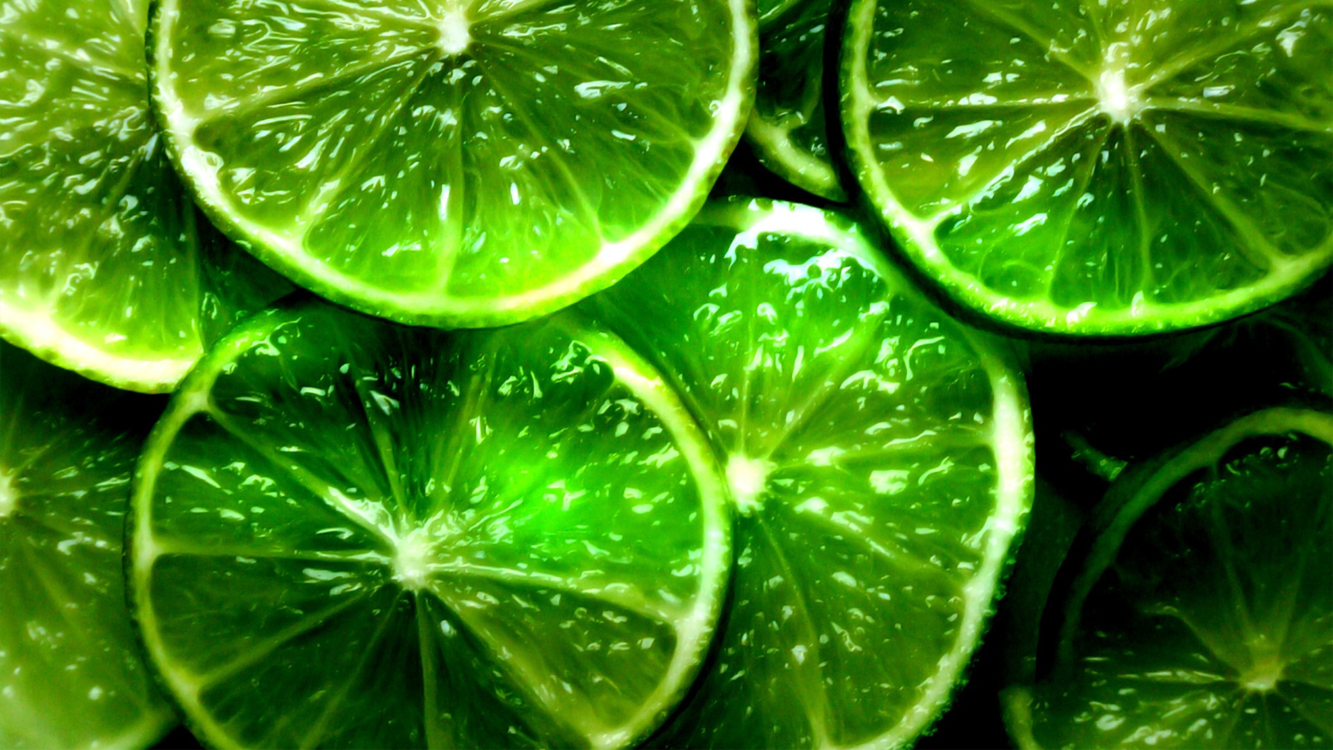 Close-up of vibrant lime slices, showcasing their juicy texture and bright green color. Perfect for a refreshing desktop background