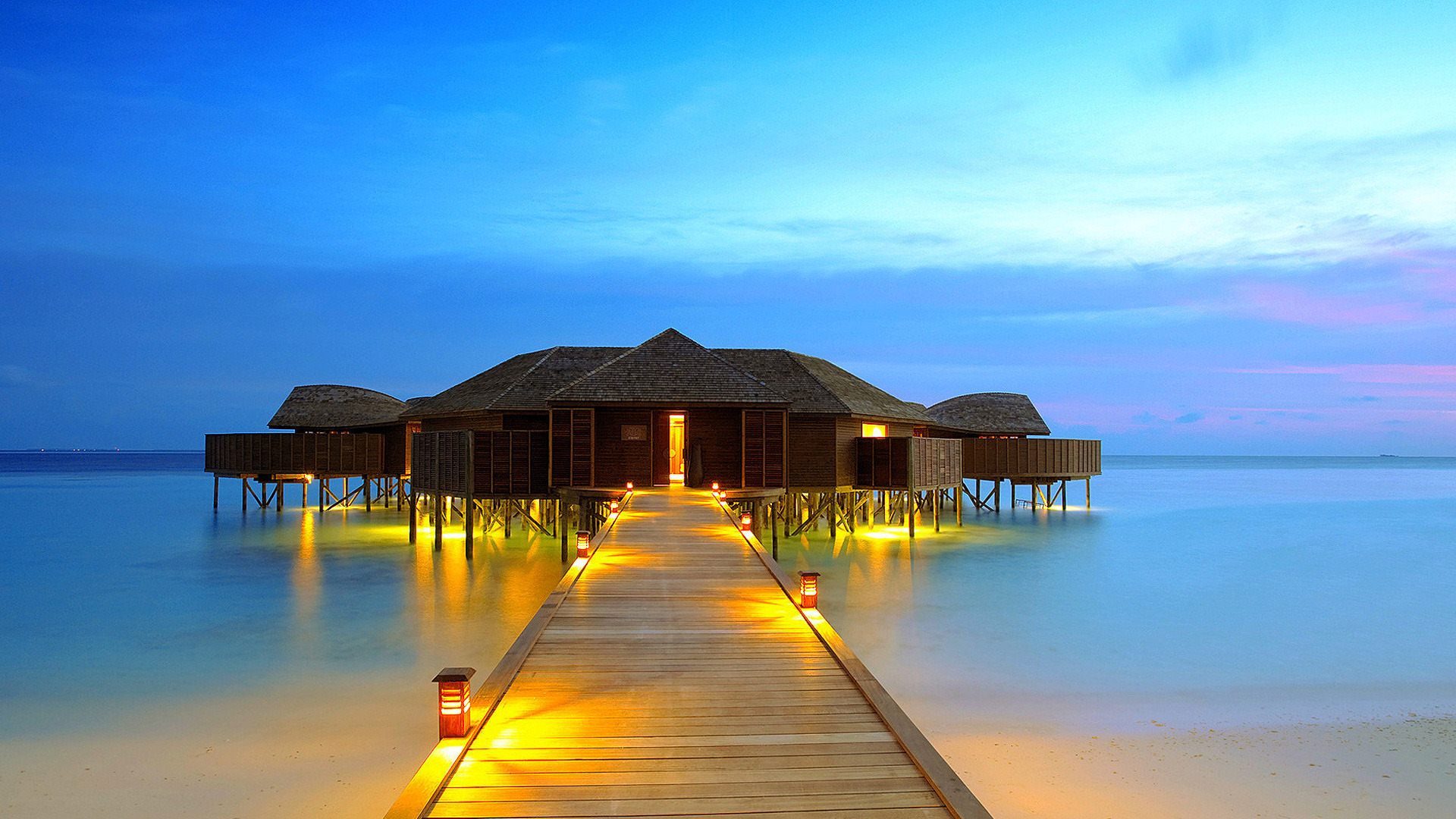 Luxury overwater bungalow at sunset on a tropical island in the Maldives