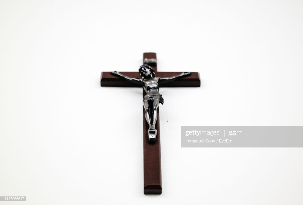 Closeup Of Crucifix Against White Background High Res Stock Photo