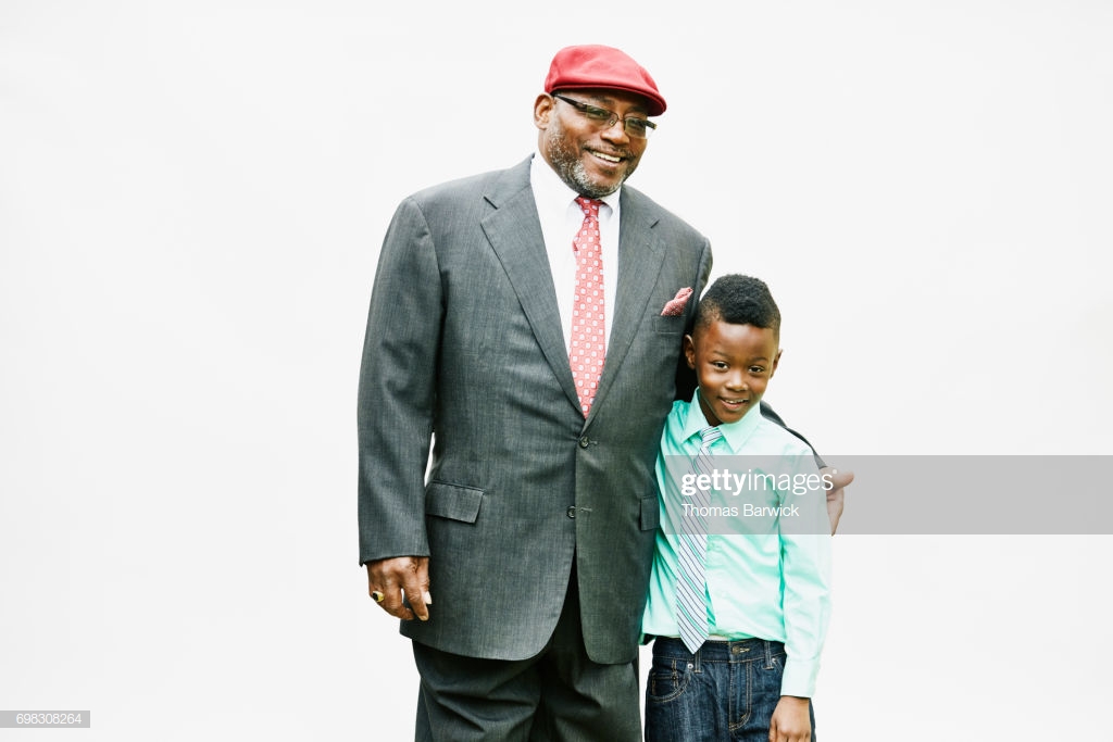 Portrait Of Smiling Uncle And Nephew Embracing In Front White