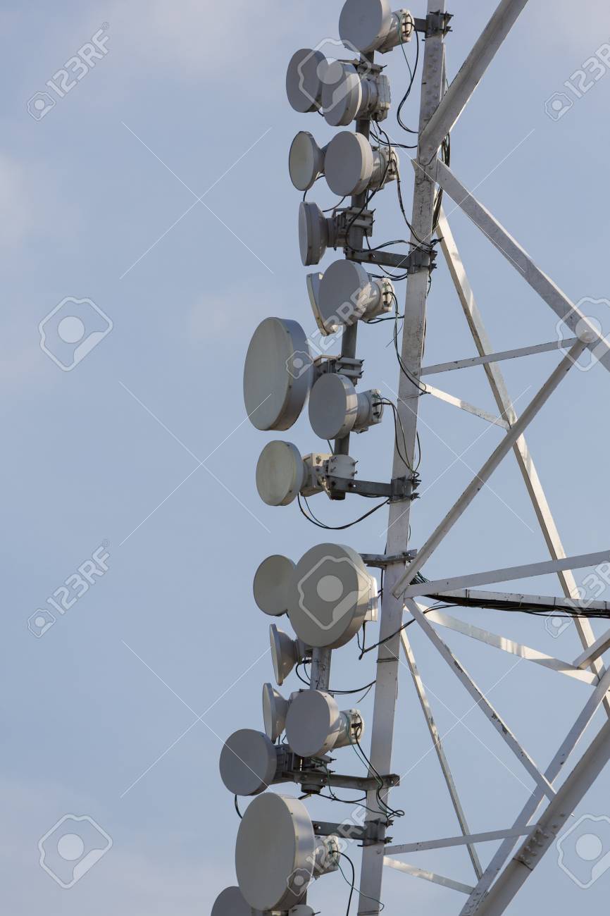 Munication Tower And Satellite Dishes On Blue Sky Background