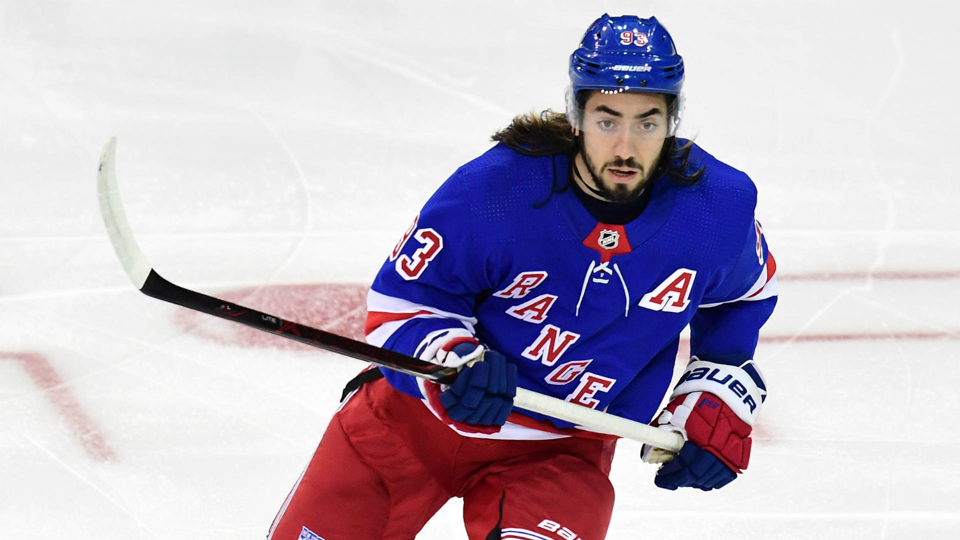 New York Rangers player skating with the puck during an NHL game