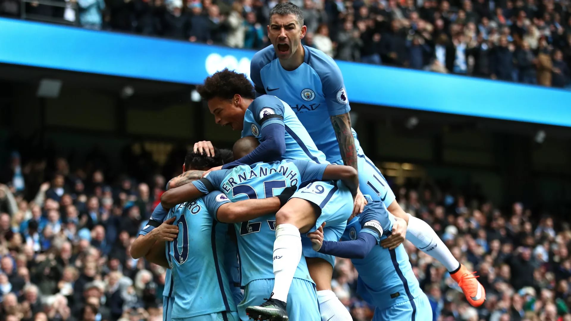 Manchester City players celebrating a goal at their home stadium
