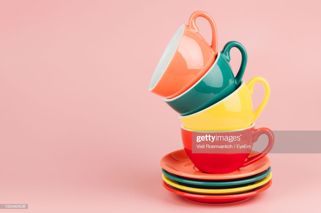 Colorful Coffee Cups And Saucer Over Pink Background Stock Photo