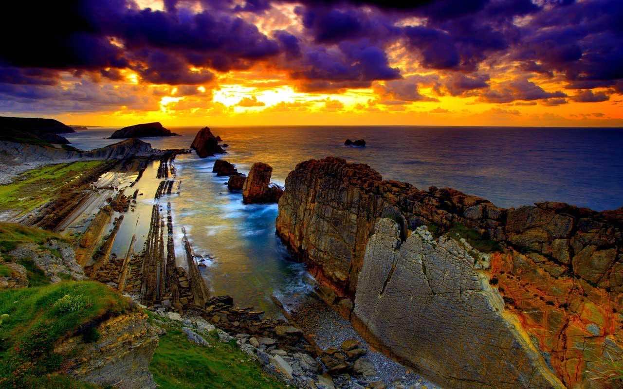 Dramatic sunset over a rocky coastline with unique geological formations