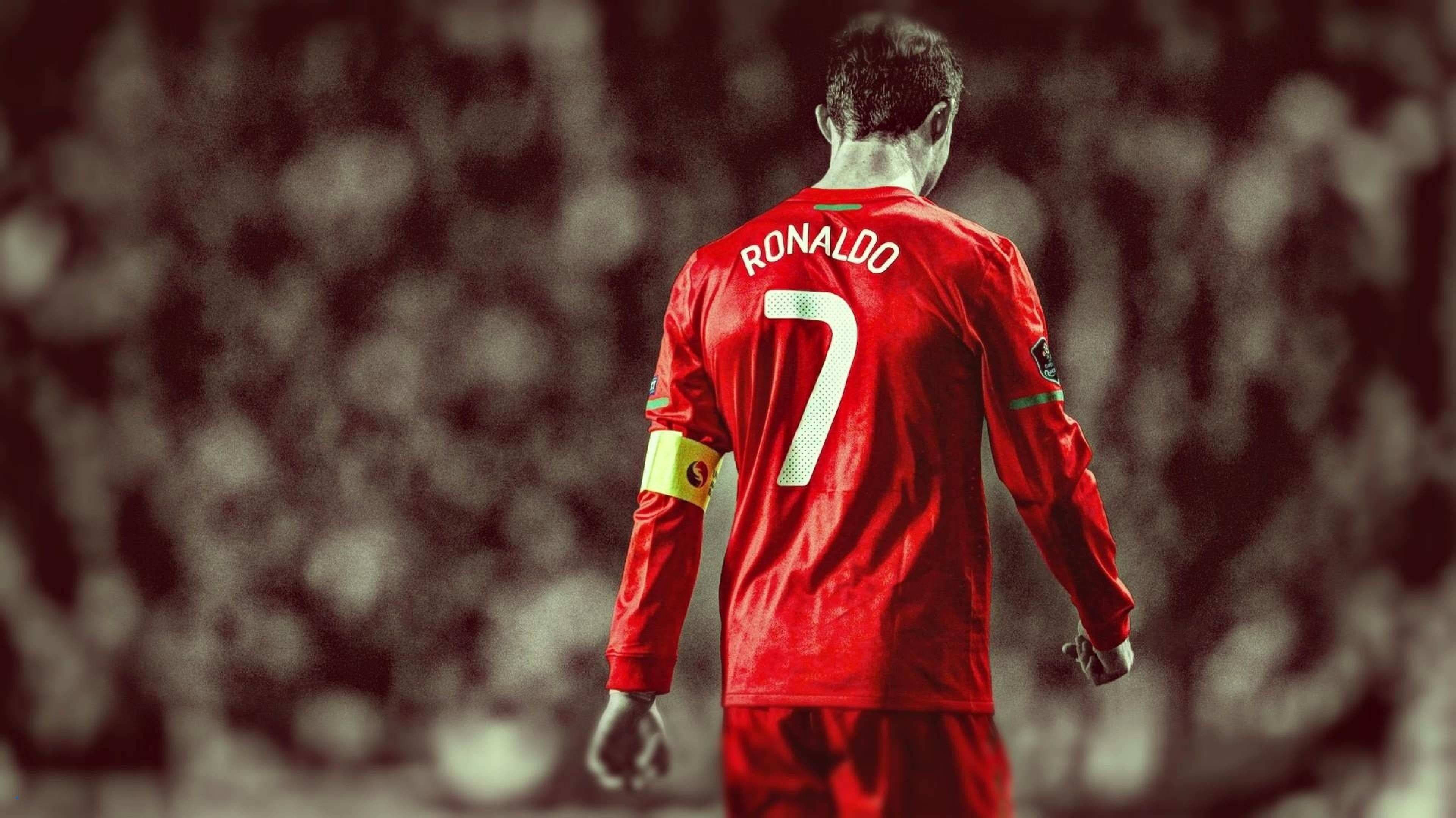 Cristiano Ronaldo, Portugal's iconic #7, seen from behind in a classic red jersey, likely during an international match. The blurred stadium background adds to the dramatic and focused feel of the image