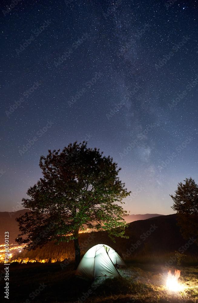 Tourist Camping Near Big Tree At Summer Night Illuminated Tent