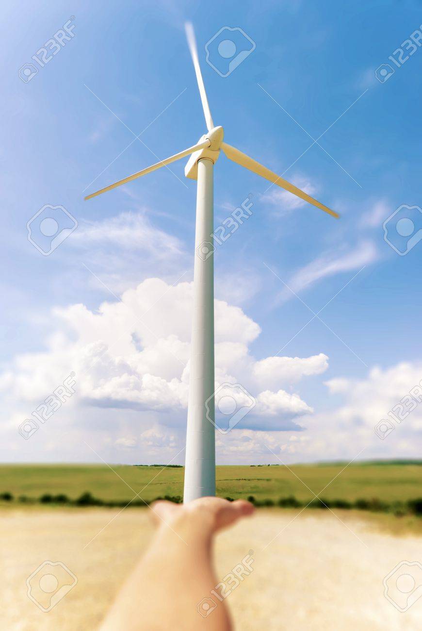 Hand Holding A Windmill Background Blue Sky With Clouds Stock