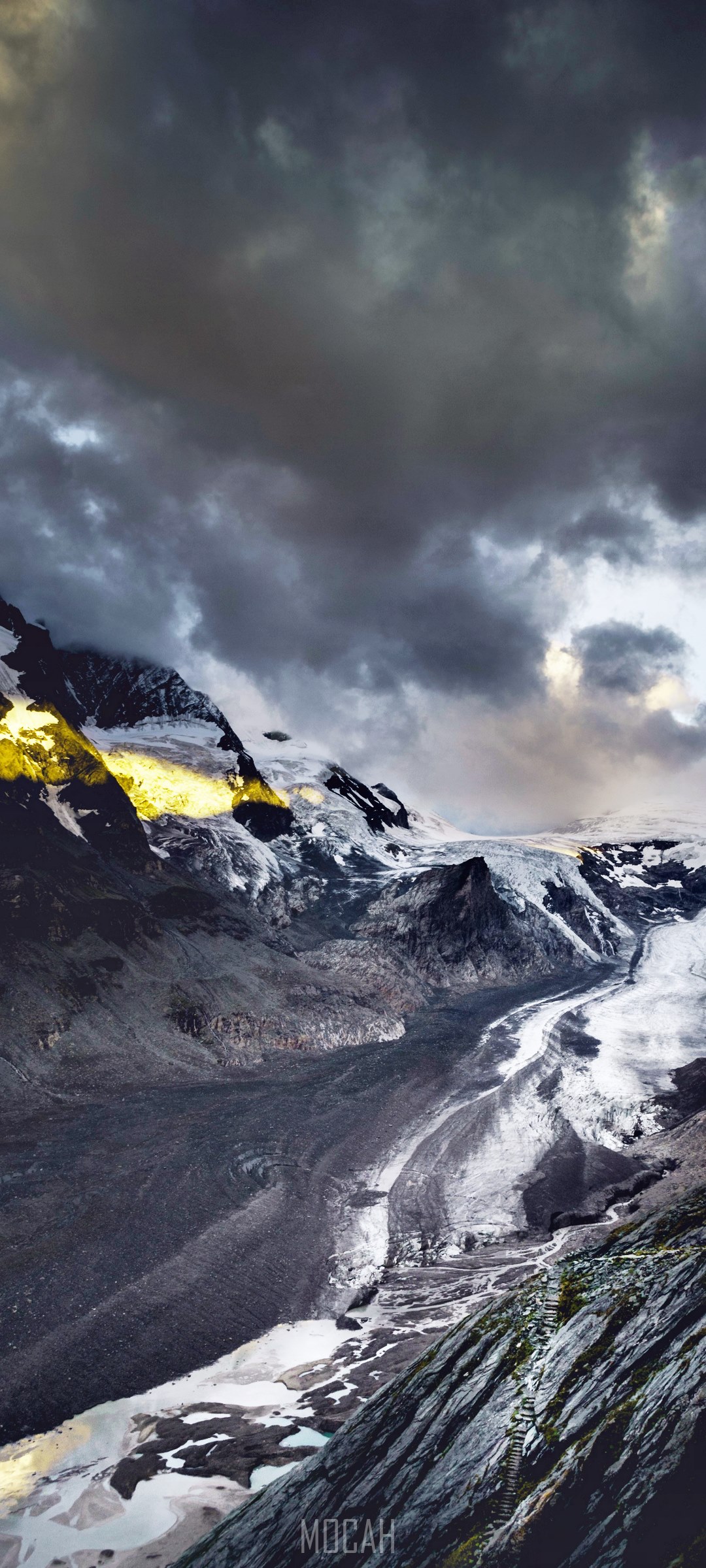 A dramatic landscape of a glacier descending from snow-capped mountains under a dark, cloudy sky