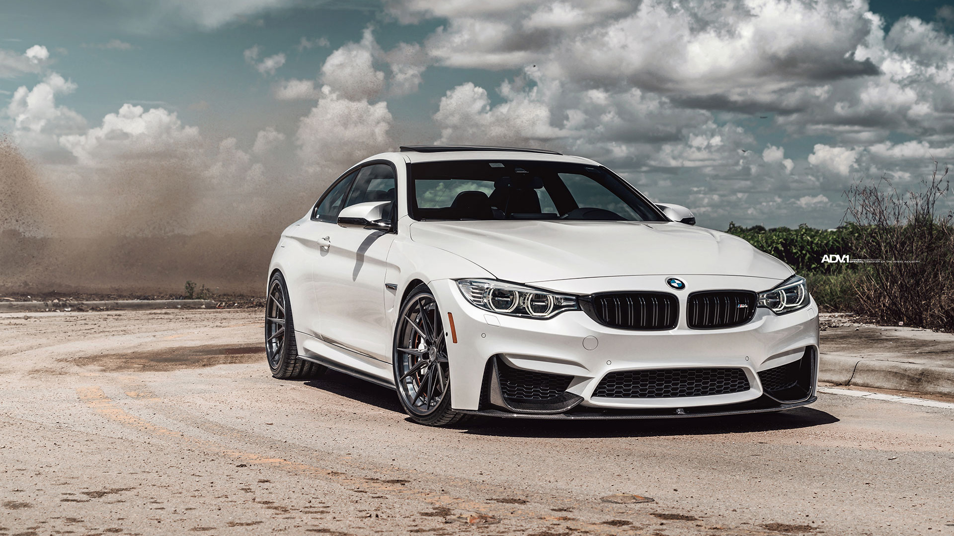 White BMW M4 Coupe on a dusty road