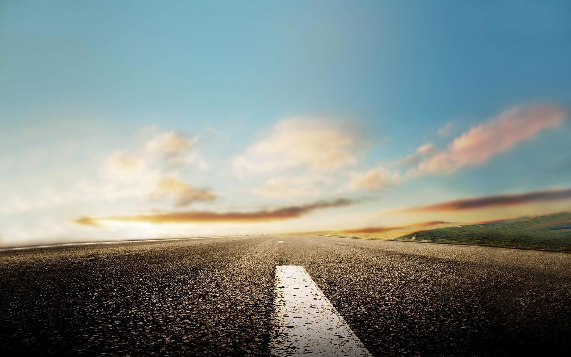 Empty road leading towards a bright horizon under a pastel sunset sky, evoking a sense of journey and academic pursuit