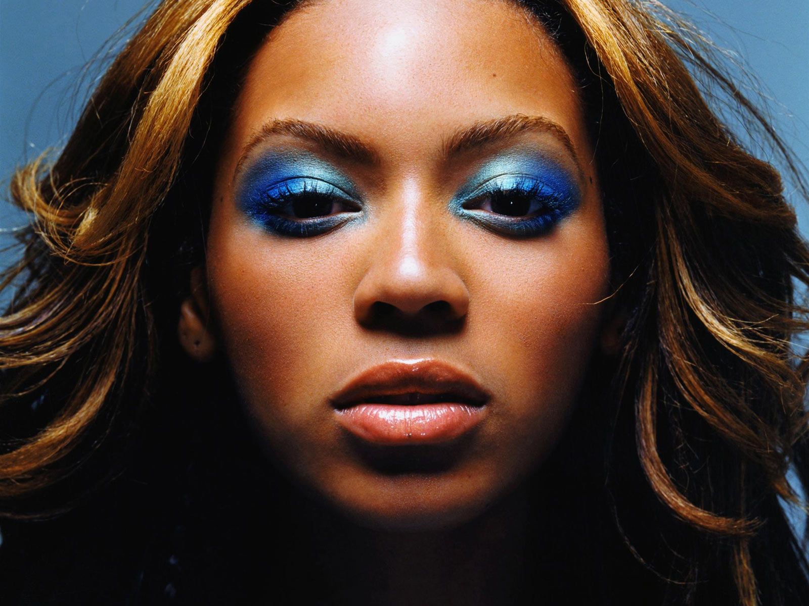 Close-up of Beyoncé with vibrant blue eyeshadow, highlighting her captivating gaze and radiant complexion