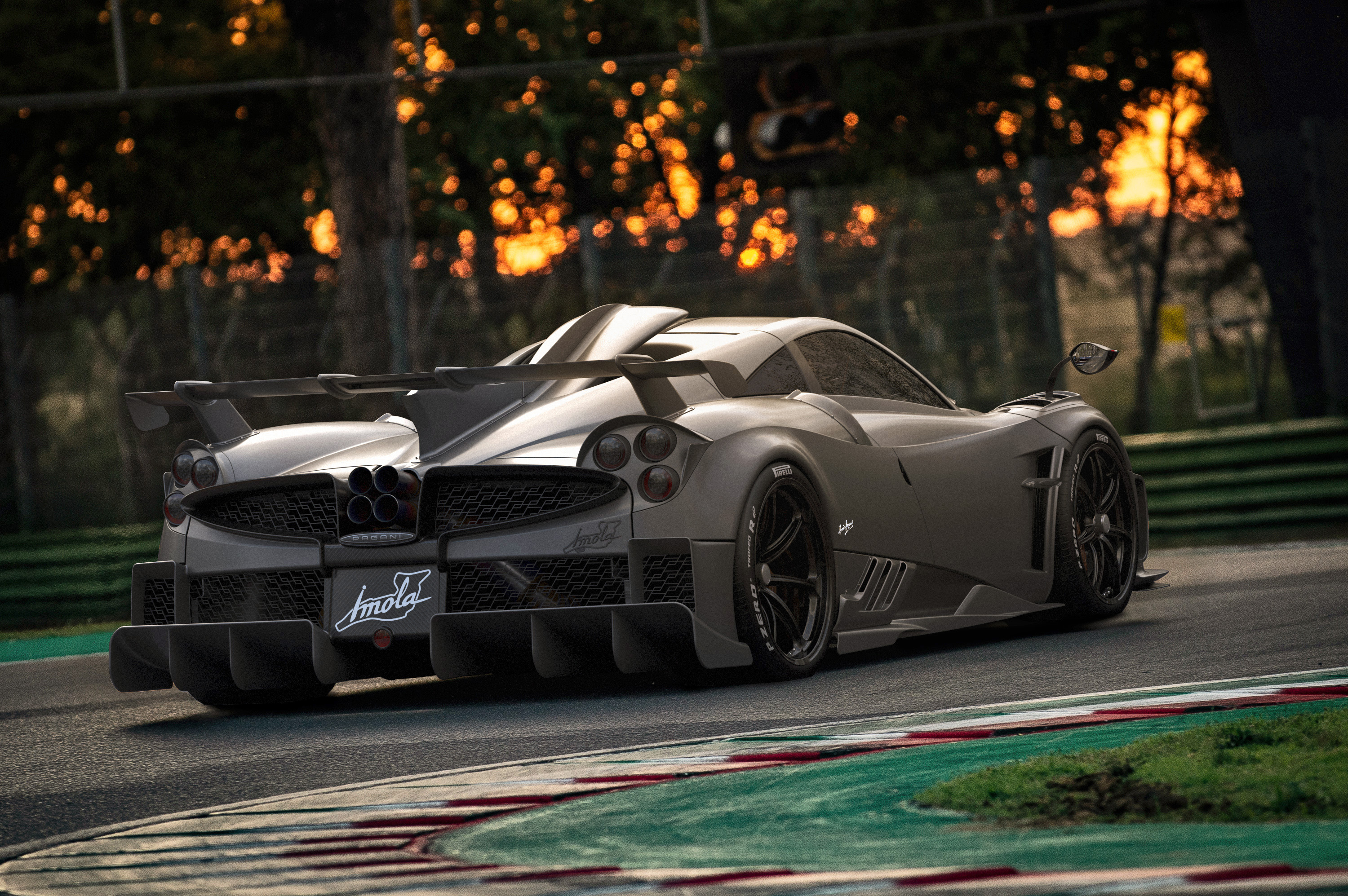 A sleek, gray Pagani Huayra Imola hypercar sits on a race track during sunset