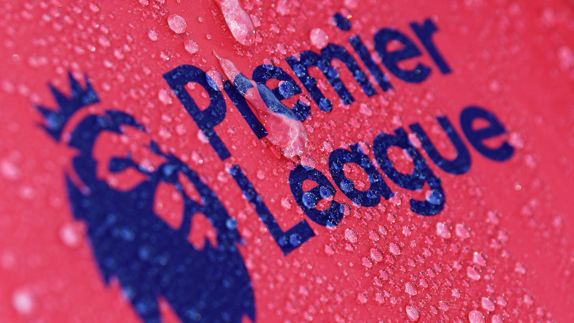Close-up of a Premier League logo on a wet surface, with water droplets adding texture and depth to the image