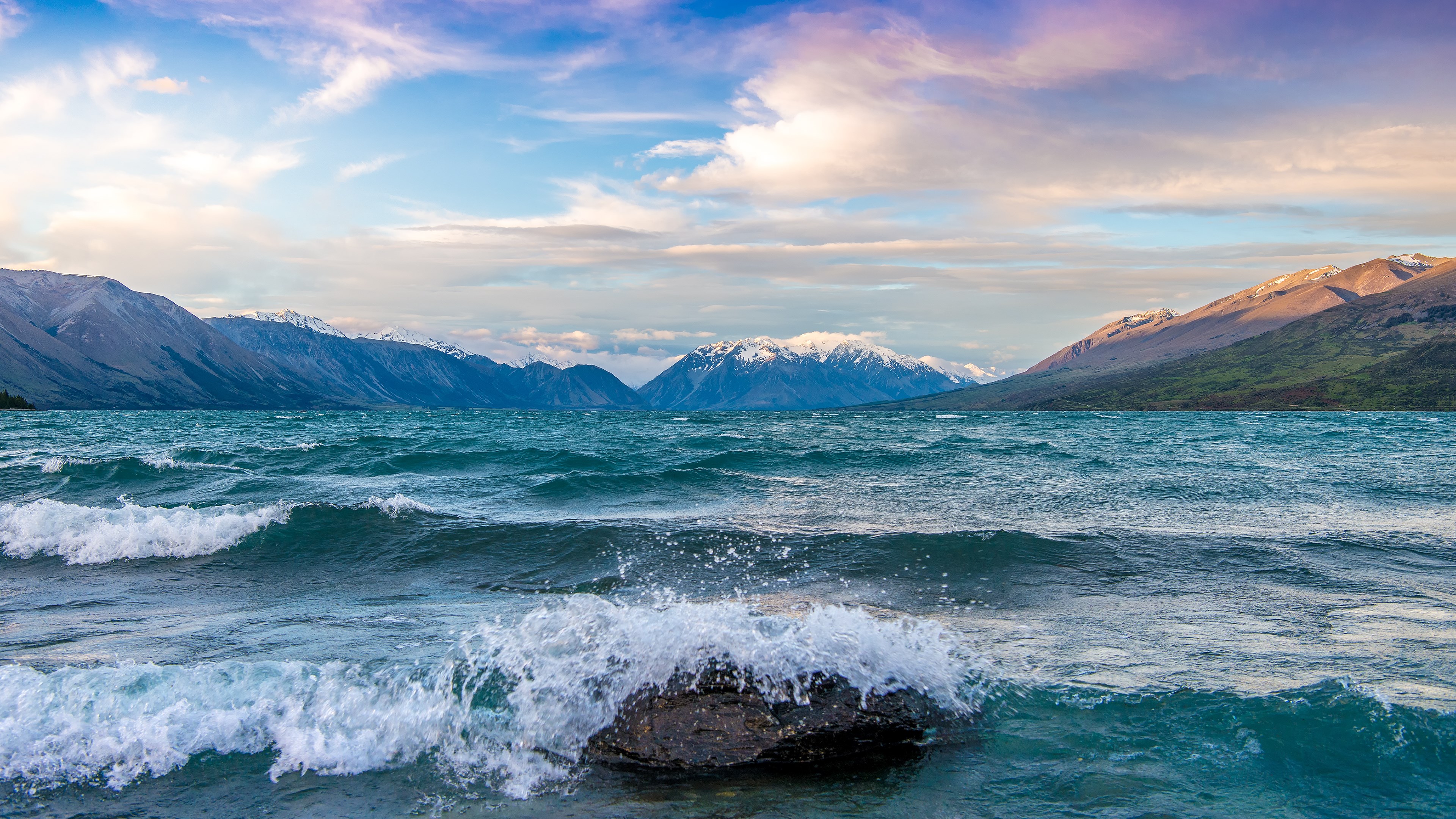 Waves Crashing on Rock in Lake with Mountain Backdrop