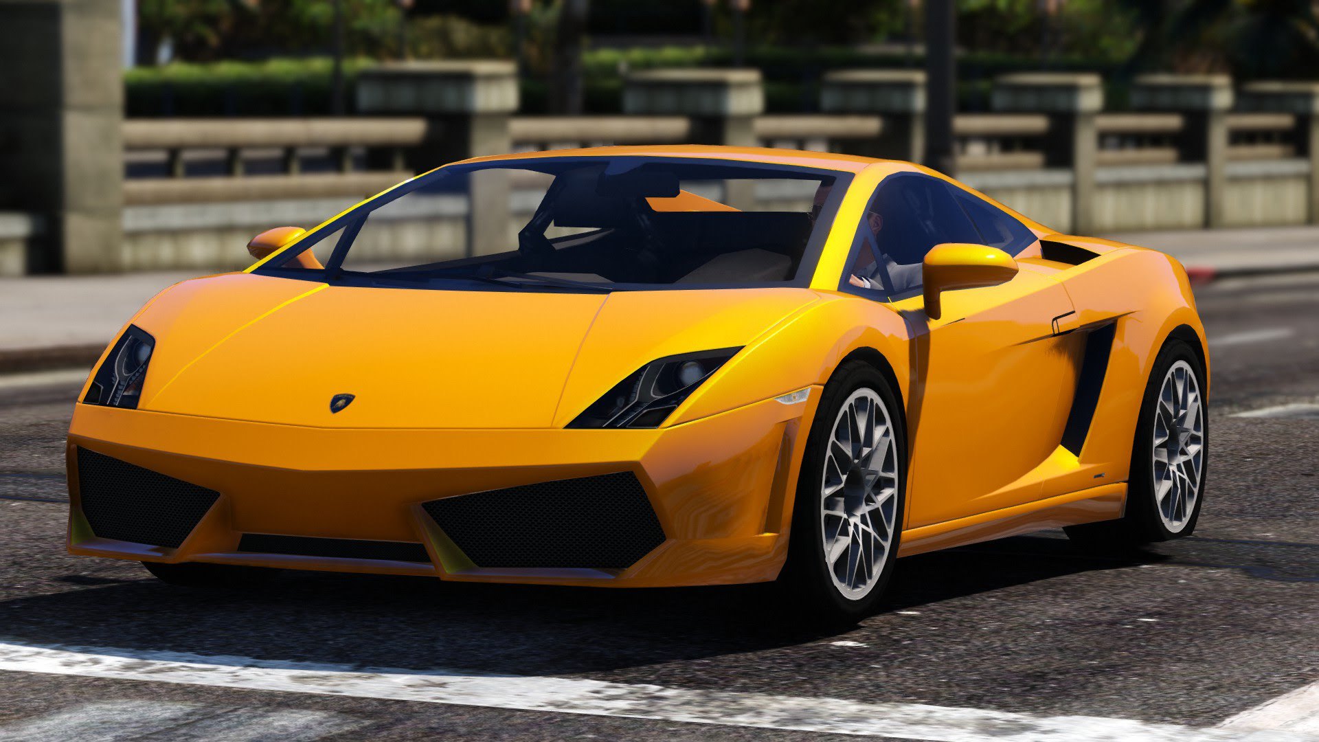 A vibrant orange Lamborghini Gallardo driving on a city street