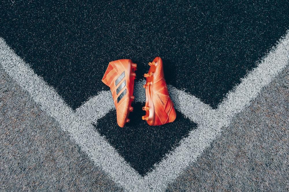 Pair Of Orange Adidas Cleats On Gray Surface Photo Sport