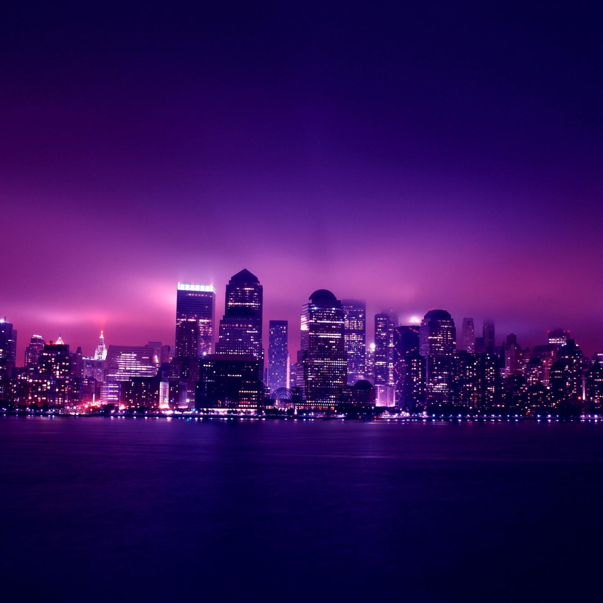 Cute iPad background featuring a city skyline at night with purple lights and a purple sky