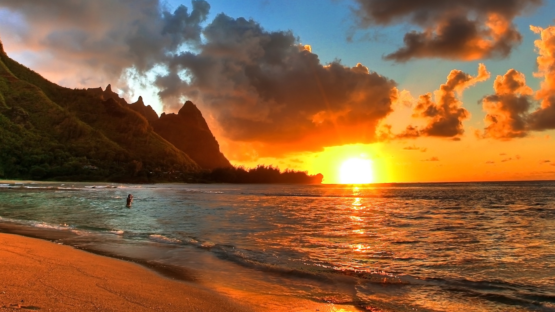A breathtaking sunset over a tranquil beach with dramatic cliffs in the background