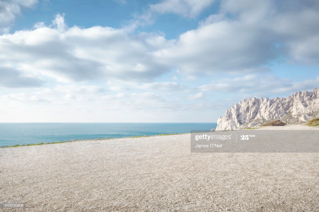Flat Gravel Plateau Next To Ocean With Background Rocks High Res