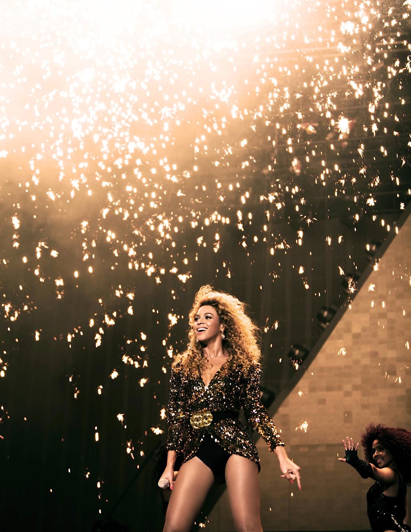 Beyoncé performing on stage with pyrotechnics in the background