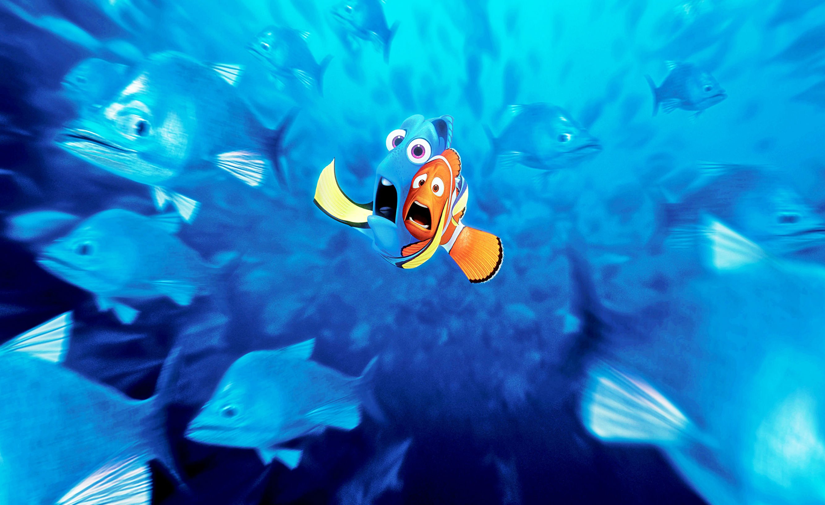 Marlin and Nemo, the two main characters from Finding Nemo, swim through a school of fish in the vast ocean