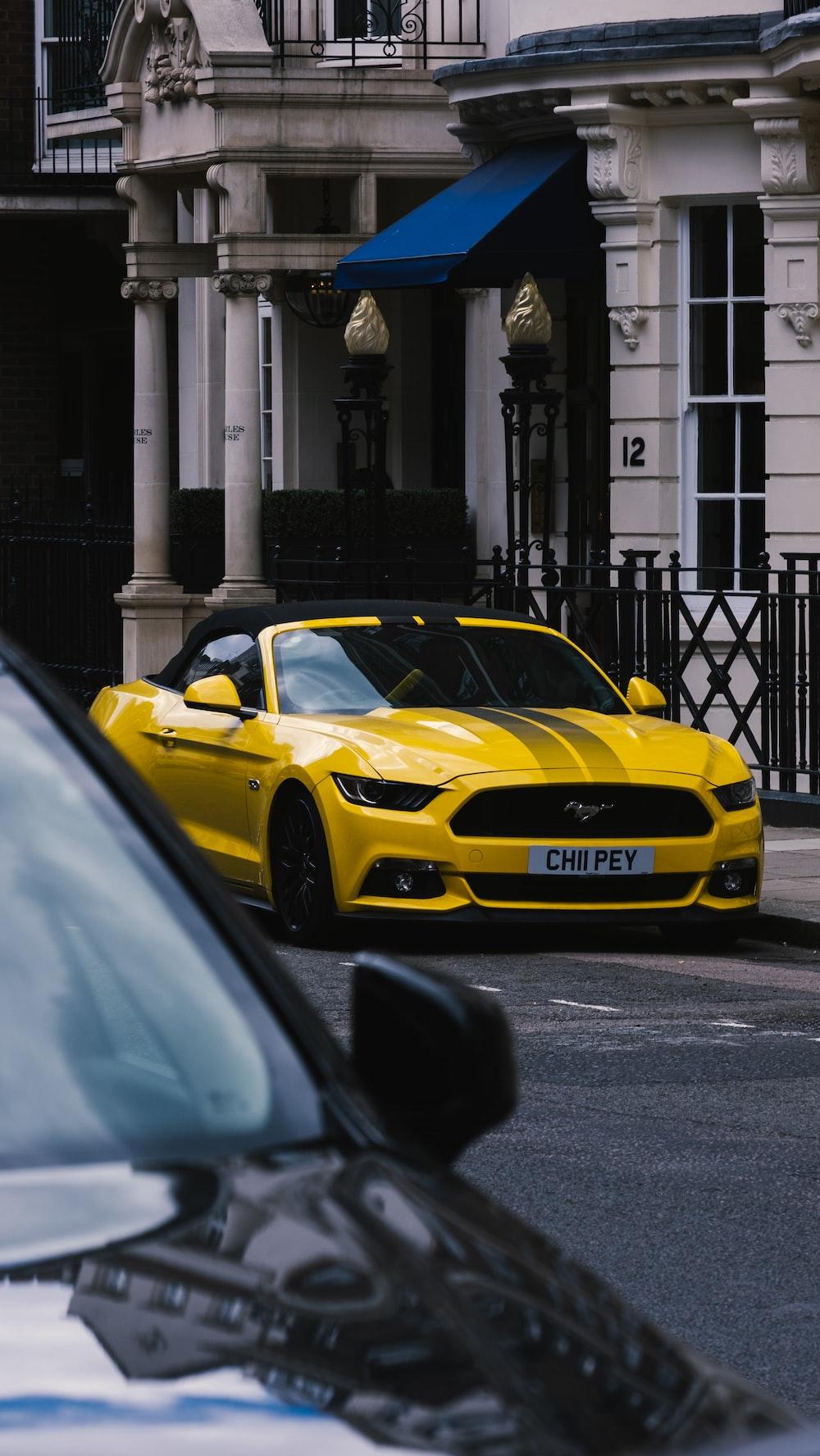 A Yellow Sports Car Parked On The Side Of Road Photo