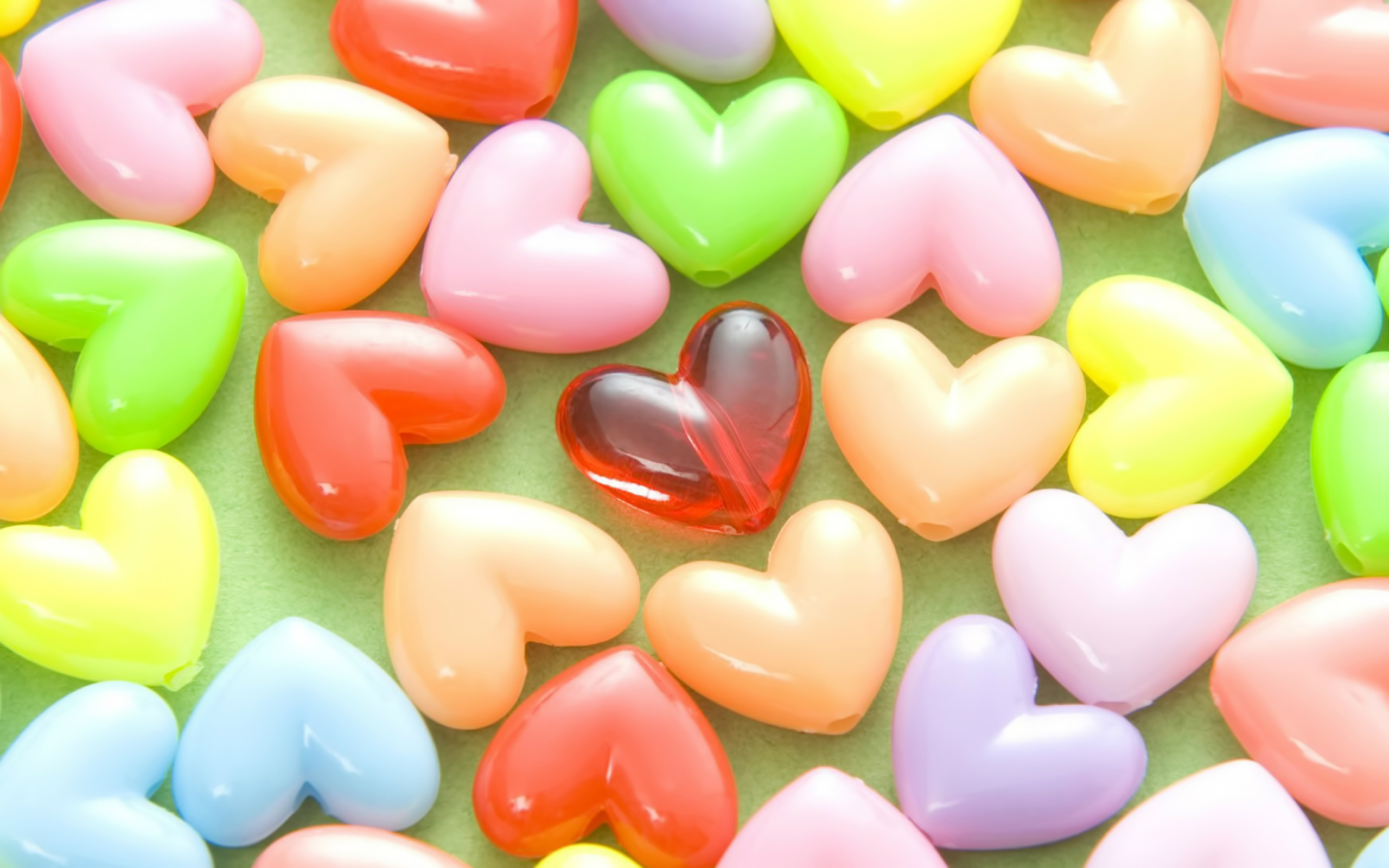 Colorful Heart-Shaped Beads on a Green Background