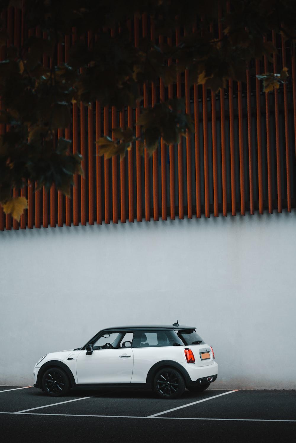 White Car Parked Beside Brown Wall Photo Herlands Image