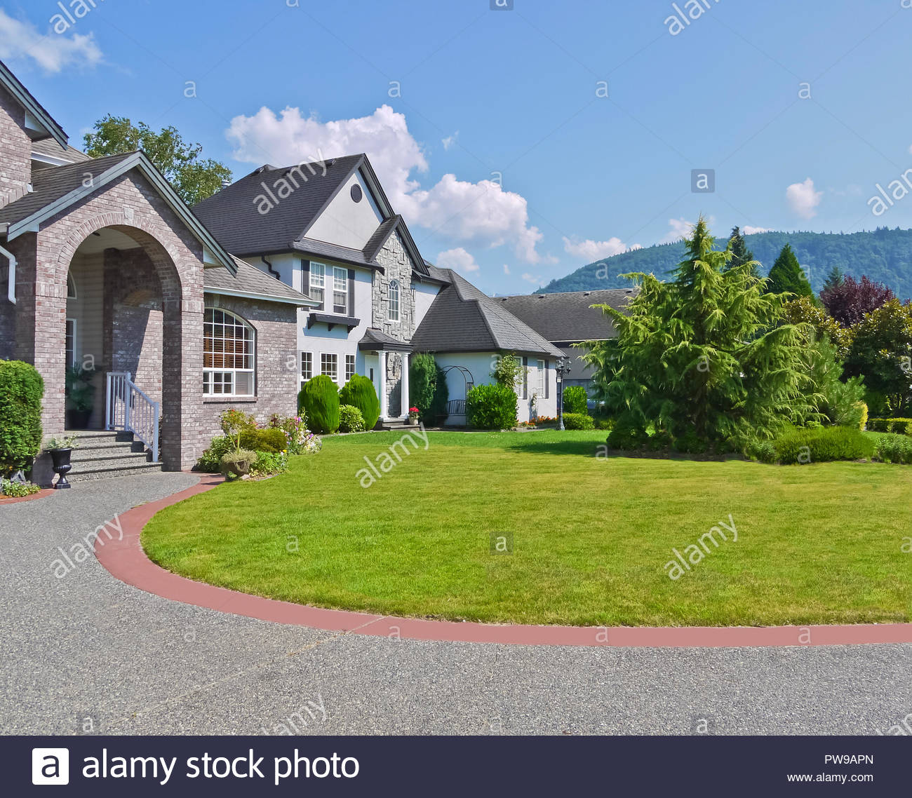 Rounded Driveway And Lawn In Front Of Residential Houses On Blue
