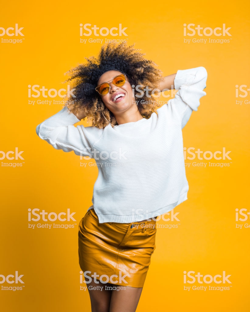 Happy Afro Girl Dancing Against Yellow Background Stock Photo