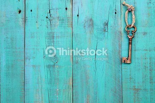 Bronze Skeleton Key Hanging On Antique Teal Blue Wooden Background