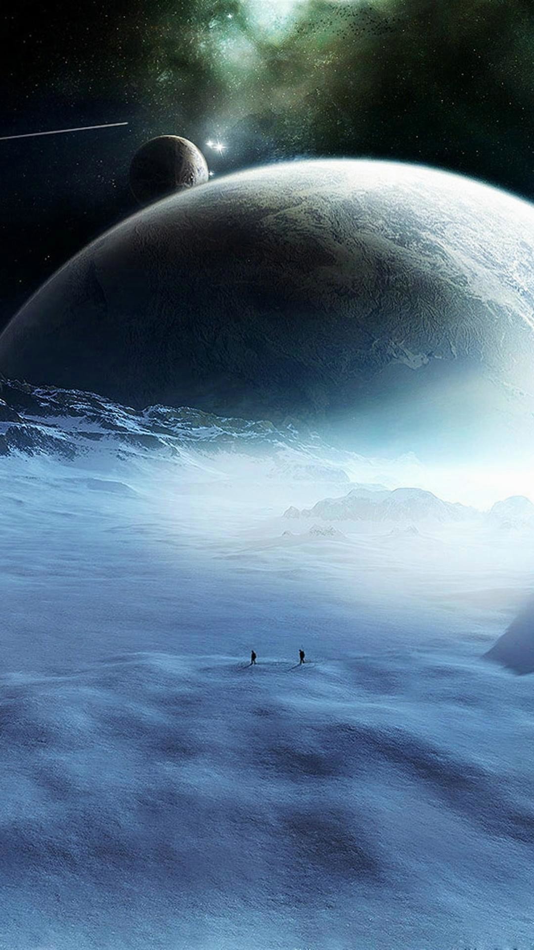 Two figures trek across a vast, snowy landscape under a large, looming planet and a smaller, distant moon in this cool phone wallpaper