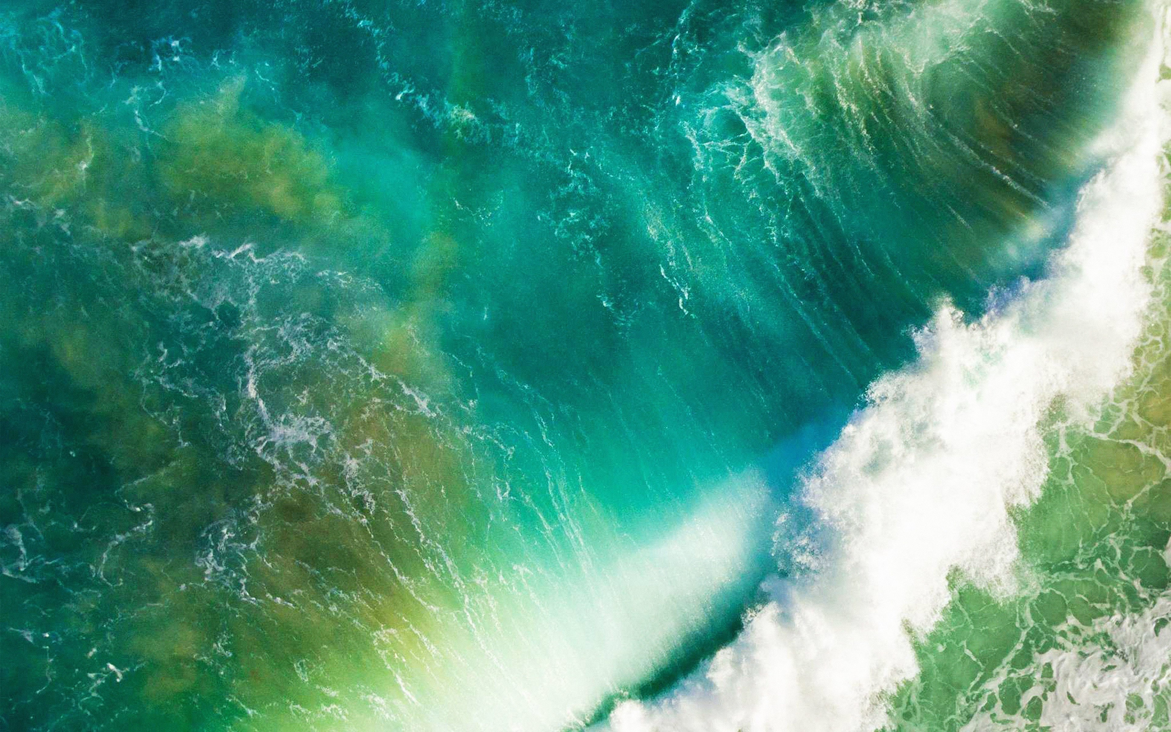 Aerial view of turquoise and green ocean waves crashing, suitable for a MacBook 4k wallpaper