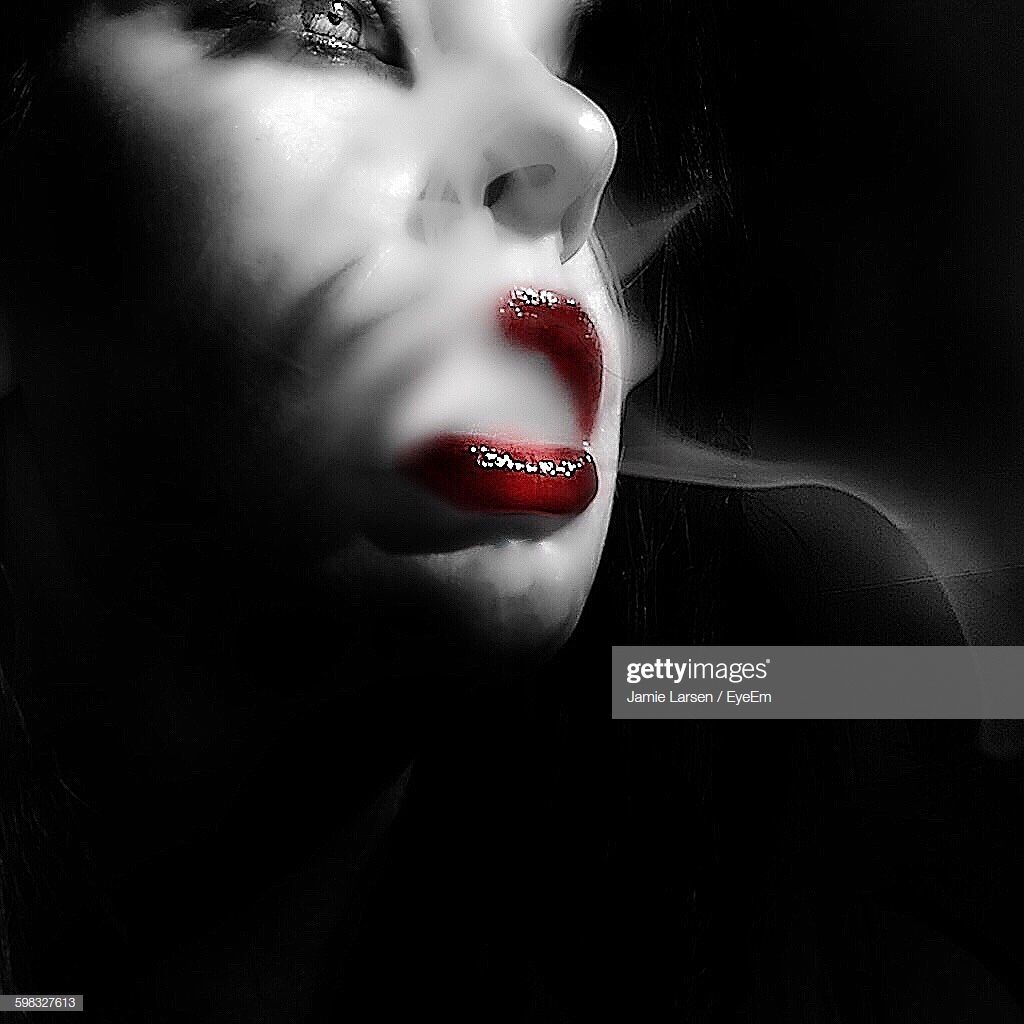 Closeup Of Seductive Woman Smoking Against Black Background High
