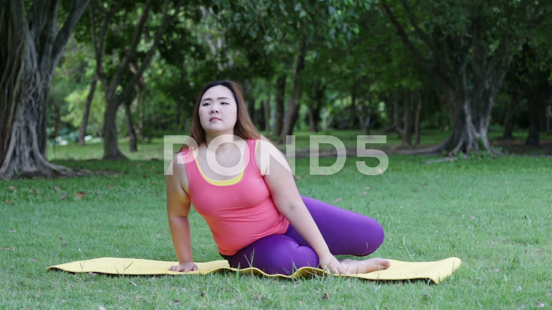 Beautiful Fat Woman Doing Yoga Seat Twist On The Mat In Park