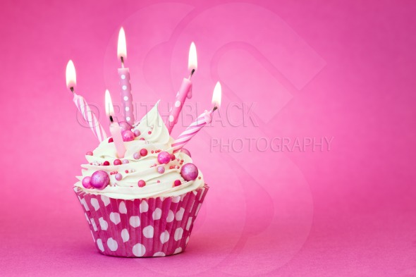Cupcake Decorated With Pink BirtHDay Candles On A Background