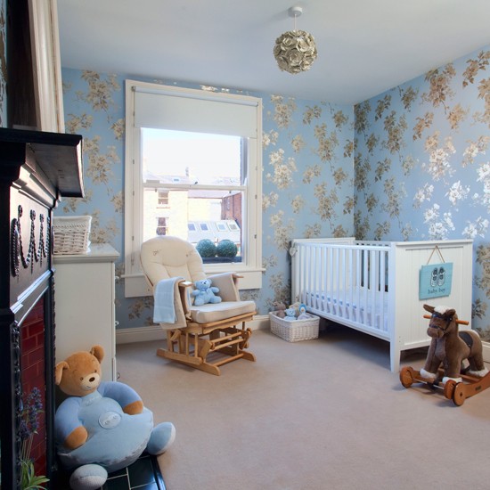 This pretty nursery is decorated with pale blue and gold wallpaper for