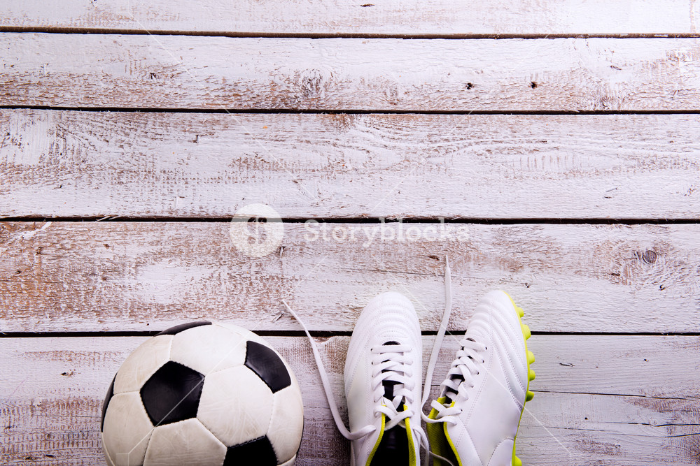Soccer Ball Cleats Against Wooden Floor Studio Shot On White
